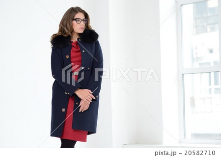 Girl in coat posing at studio Girl in coat posing at studio 20582710