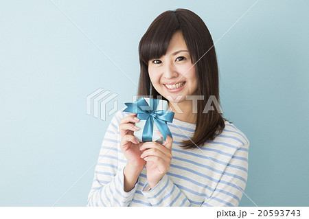 プレゼントを差し出す若い女性の写真素材
