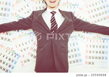 カレンダーの前で笑顔のビジネスマン 20594698