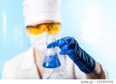Woman chemist examines test tube Woman chemist examines test tube 20595439