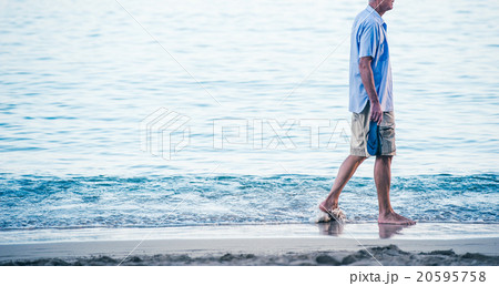 海岸を寂しく歩く中年の男性 20595758