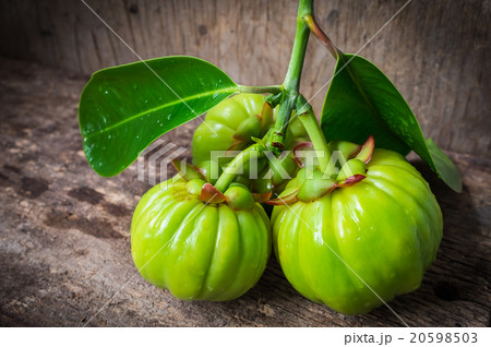 Still life with fresh garcinia cambogia on wooden background (Th 20598503
