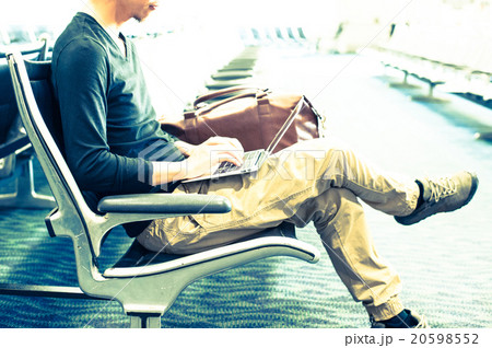 空港の待合室でノートパソコンを使っている男性 20598552