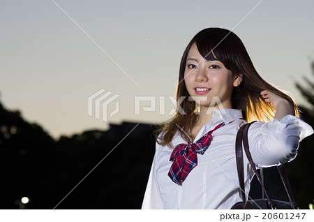 夕方一人で下校しながら髪をなびかせる女子学生 下校 生徒 女子高校生の写真素材