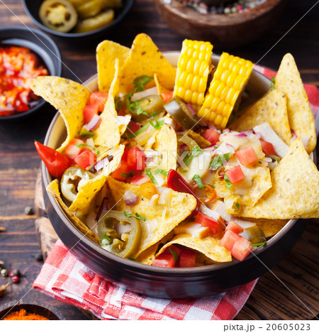 Nachos with melted cheese sauce, salsa, corn cobs 20605023