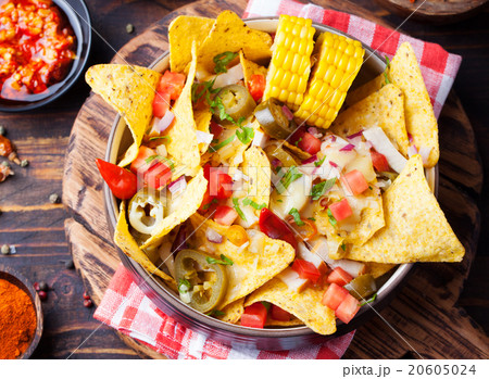Nachos, cheese sauce, salsa and corn cobs Top view Nachos, cheese sauce, salsa and corn cobs Top view 20605024