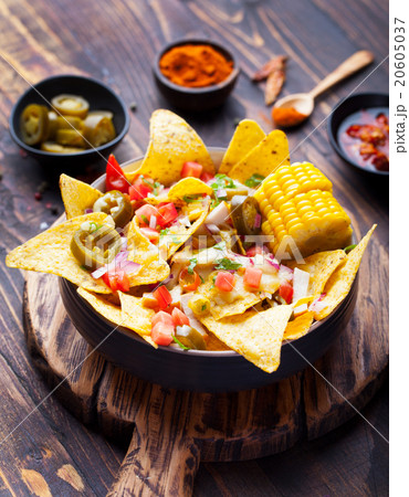 Nachos with melted cheese sauce, salsa, corn cobs 20605037