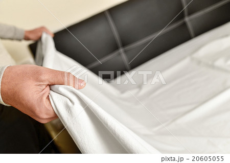 young man making the bed 20605055