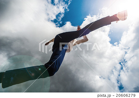 カメラの上を飛び越える男性 ローアングルの写真素材