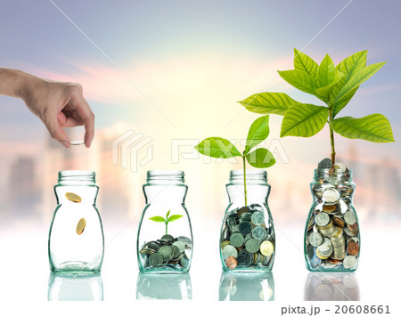 Hand putting mix coins and seed in clear bottle on cityscape pho Hand putting mix coins and seed in clear bottle on cityscape pho 20608661