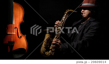 A saxophone player in a dark background 20609014