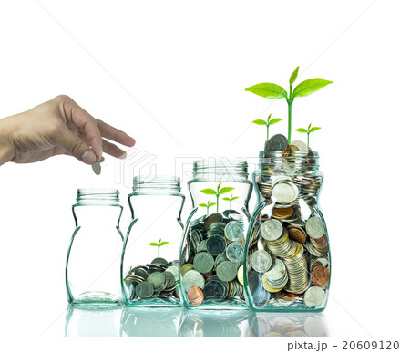 Hand putting mix coins and seed in clear bottle on white backgro Hand putting mix coins and seed in clear bottle on white backgro 20609120
