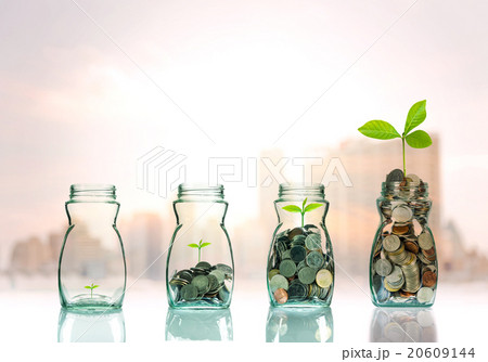 Mix coins and seed in clear bottle on cityscape photo blurred ci Mix coins and seed in clear bottle on cityscape photo blurred ci 20609144