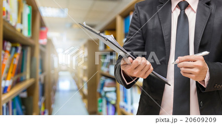 Businessman writing the file pad on the Abstract blurred photo o Businessman writing the file pad on the Abstract blurred photo o 20609209
