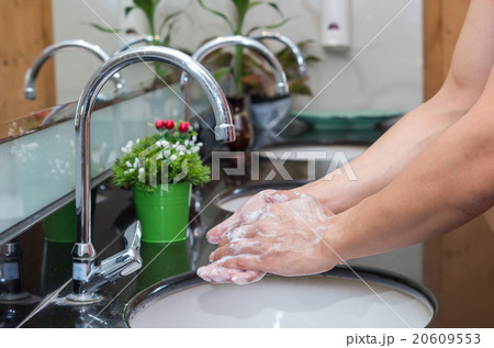Hand washing with Chrome faucet over the washbasin in modern bat Hand washing with Chrome faucet over the washbasin in modern bat 20609553