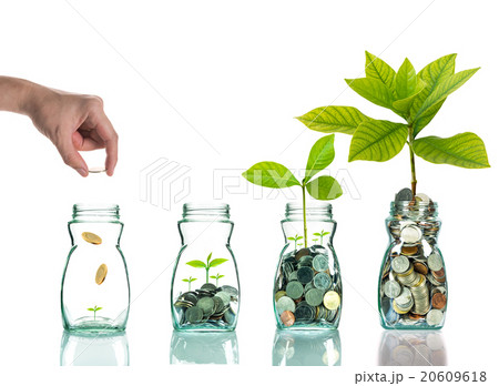 Hand putting mix coins and seed in clear bottle on white backgro Hand putting mix coins and seed in clear bottle on white backgro 20609618