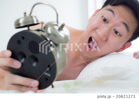 Young man on bedside knowing he overslept and late 20621271