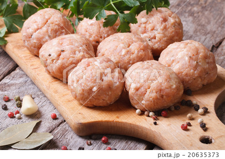 raw meatballs on a chopping board and ingredients. raw meatballs on a chopping board and ingredients. 20635373