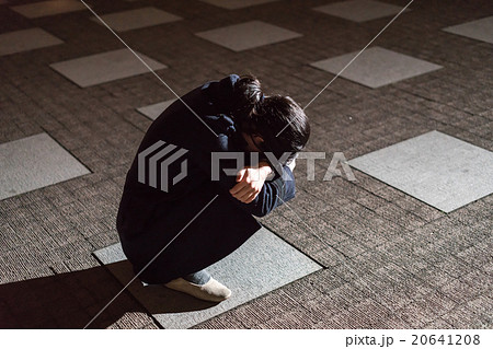 路上でうずくまる女性の写真素材 6418