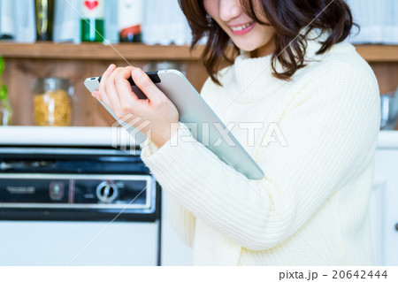 台所でタブレットPCを操作する女性の手元　白い　台所　キッチン　調理場　レシピ検索　メニュー検索 20642444