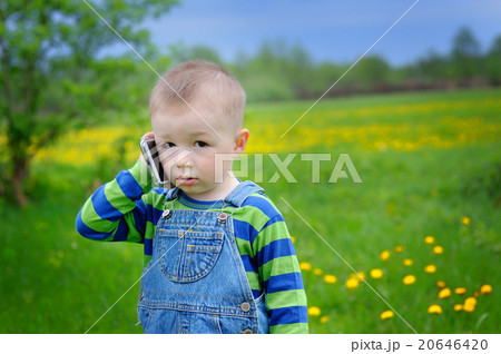 little boy talking on the phone on a spring meadow little boy talking on the phone on a spring meadow 20646420