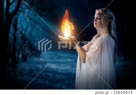Elven girl holding fire in palms at night forest 20650074
