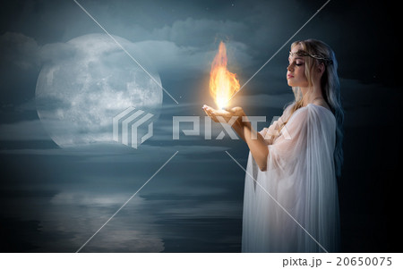 Elven girl holding fire in palms at sea shore 20650075