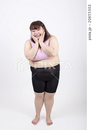 白い背景の前で両手を頬にあてて笑顔の太った若い女性の写真素材 20655303 Pixta