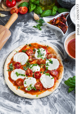 Prepering margherita pizza with mozzarella Prepering margherita pizza with mozzarella 20659777