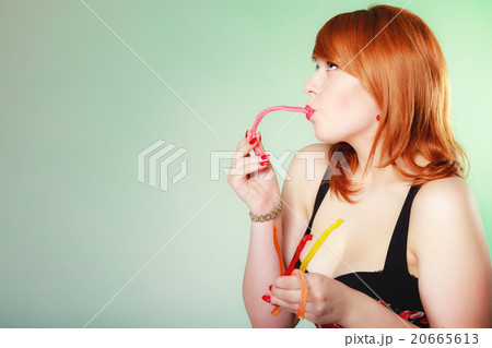 Redhair girl holding sweet food jelly candy on green. Redhair girl holding sweet food jelly candy on green. 20665613