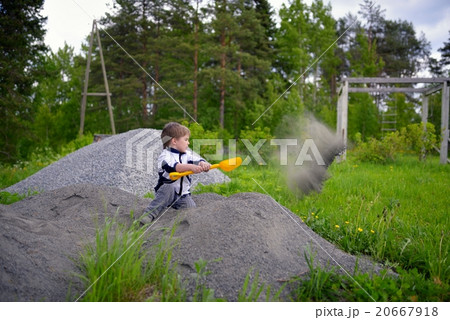 Little boy plays on heap of crushed stone Little boy plays on heap of crushed stone 20667918