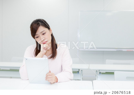 タブレットを見ながら考え込む女性 タブレットを見ながら考え込む女性 20676518