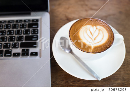 Hot latte and laptop on wooden table Hot latte and laptop on wooden table 20678293