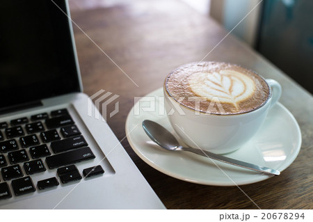 Hot latte and laptop on wooden table 20678294