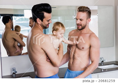 Happy gay couple holding their child 20681259
