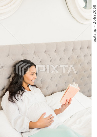 Pregnant brunette reading a book Pregnant brunette reading a book 20682069