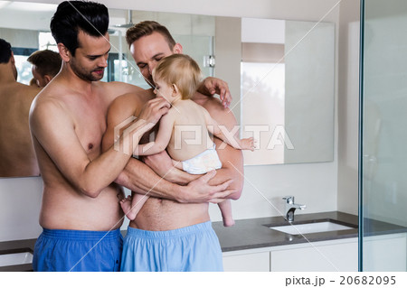 Happy gay couple holding their child 20682095