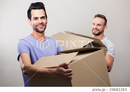 Happy gay couple holding boxes 20682263