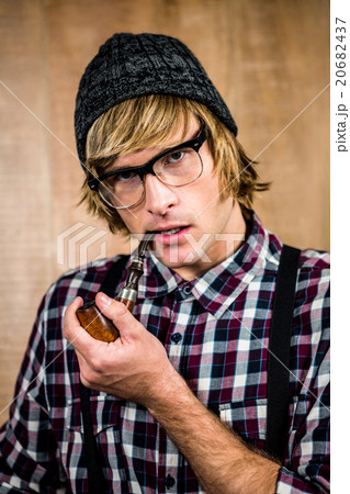 Serious blond hipster smoking a pipe 20682437