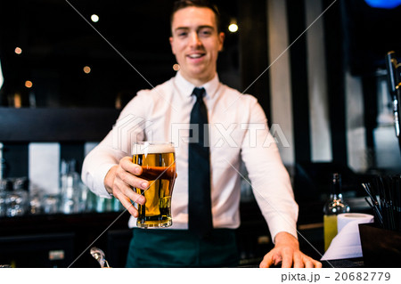 Barman serving a pint of beer Barman serving a pint of beer 20682779