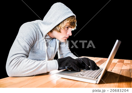 Focused man with hoodie typing on laptop Focused man with hoodie typing on laptop 20683204
