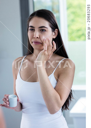 Brunette applying face cream Brunette applying face cream 20683293