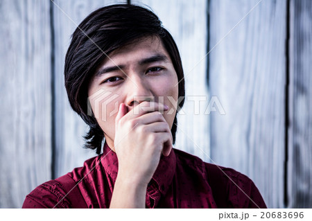 Hipster yawning with his hand over his mouth Hipster yawning with his hand over his mouth 20683696