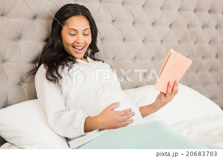 Pregnant brunette reading a book 20683703