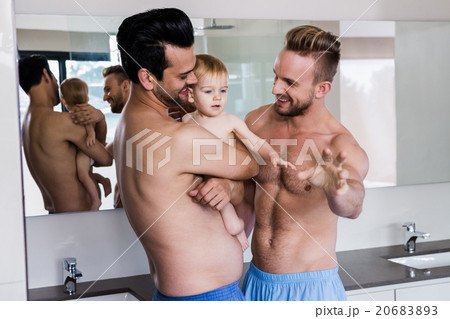 Happy gay couple holding their child 20683893