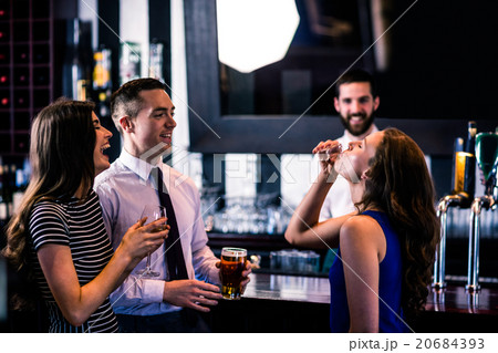 Woman having a shot with friends Woman having a shot with friends 20684393