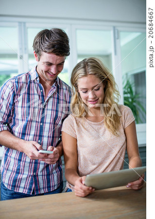 Cute couple using tablet computer in the kitchen 20684667