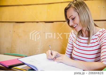happy female student writing notes 20684820