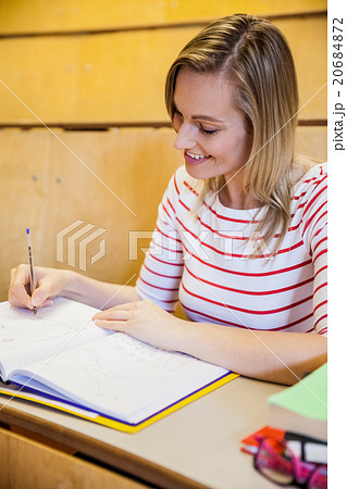 happy female student writing notes 20684872