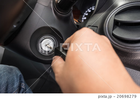 Hand putting car key to the keyhole 20698279